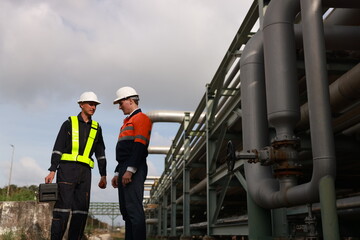 Construction engineers supervising the project's progress for the piping system stand on the new...