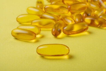 omega 3 capsules on a yellow background
