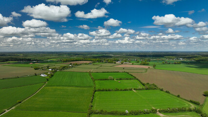 Drone footage view of the meadows in Ireland with beautiful blue sky and clouds