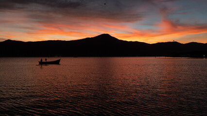 Barco Pôr do Sol Céu Colorido Vermelho Laranja Lagoa da Conceição Floripa Florianópolis Paisagem Natural Reflexo Água Beleza Tranquilidade Natureza Final de Tarde Cenário Deslumbrante Floripa Brilho