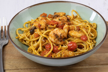 spaghettis aux crevettes et légumes grillés, en gros plan.	