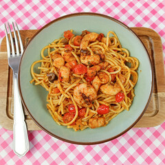 spaghettis aux crevettes et légumes grillés, en gros plan.	