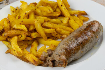 andouillette et frites, en gros plan, dans une assiette	