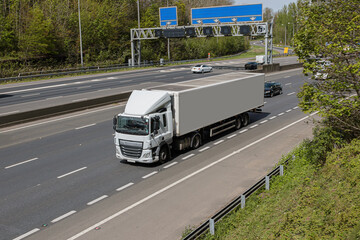 White articulated lorry travelling on the motorway.