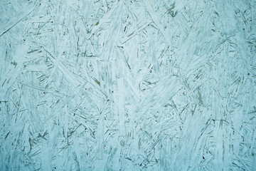 Chipboard OSB texture painted in cyan color.