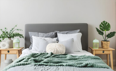 Modern house interior details. Simple cozy bedroom interior with gray bed headboard, linen bedding, bedside table and natural decorations, closeup