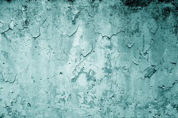 Peeling paint on grungy plaster wall. Cyan color.