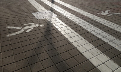 Pedestrian crosswalk sign painted on the road surface.