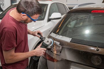 Mechanic Grinding Rear Car Door for Repairs