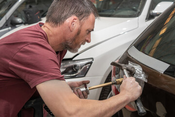 Mechanic Using Electric Dent Puller on Rear Car Door