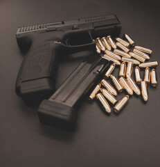 Pistolet i amunicja na czarnym tle © Marcin