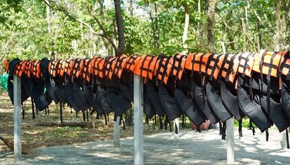 Row of orange life jackets or life vests for tourist hanging beside the beach waiting for use to...