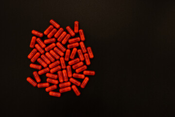 Czerwone tabletki na czarnym tle © Marcin
