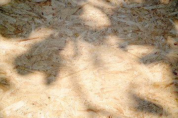 Old brown plywood recycled compressed wood chippings board texture with light and shadow for abstract background. Material design.board patterns, space for work, banner, wallpaper. Close up.