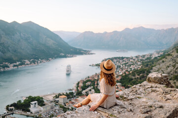 Back view of woman- travel enjoying beautiful cityscape on high viewpoint. Tourism, rest, weekend, summer trip.