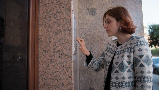 Woman Short Hair Using Intercom At Condominium Apartment