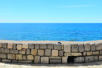 Budva, Montenegro - May 04, 2024 : The Old Town Fortress in Budva. A stone wall on the shore of the Adriatic Sea in Montenegro. Horizontal. On a hot, sunny, spring afternoon.