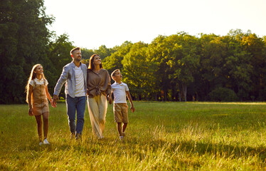 Family in nature. Young family with two children is walking in park on warm summer day and enjoying...
