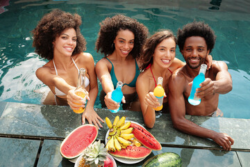 Group of diverse people having fun, smiling and cheering in a pool. Pool party. 