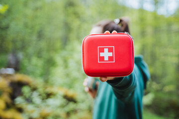 Proactive emergency preparedness in nature with a first aid kit for outdoor adventures. Human hand...