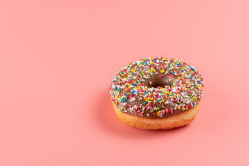 Donut with sweet color decoration on bright background. Minimal food concept.
