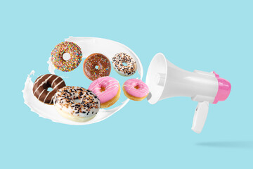 Different tasty donuts with megaphone on pastel blue background. Creative minimal food concept.