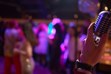 Music artist with body jewelry sings into microphone at concert