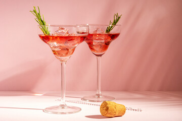 Refreshing cocktail with rosemary in a glass on a bright background. Summer party concept.