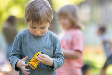 A boy is holding a toy car in his hand
