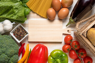 Colorful vegetables and spaghetti on wooden background with copy space.