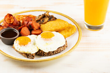 Βreakfast plate with fried eggs, sausages, nuggets and juice. Healthy food concept.