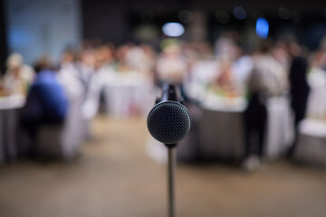 Microphone on stand before crowd, part of public address system at event