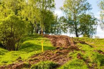 Dug up earth in a picturesque area after laying a gas pipeline, gasification in the countryside