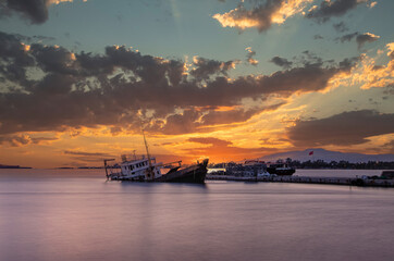 Naklejka premium Sunken cargo ship lying on its side at sunset in Aliaga Bay, Izmir.