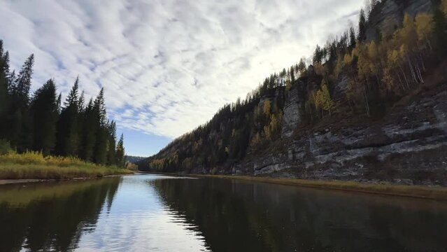 Perm Region, Usva - September 2023. Boat trip to the Usva pillars. A view of the flashing autumn trees and the lapping of the waves from a boat sailing down the river.4К