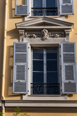 Architectural fragments of the facades of ancient houses in Nice: beautiful windows, balconies, shutters. Nice, capital of the Alpes-Maritimes department on the French Riviera.