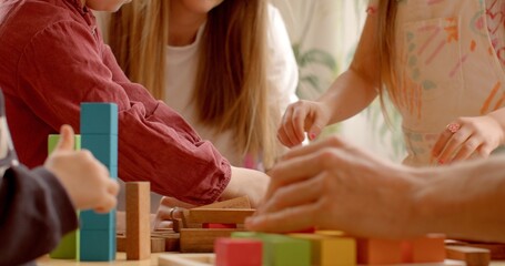 Montessori materials for early development. Montessori method's focus on tactile exploration and independent discovery. Children playing in a preschool. Close-up of hands with wooden 
