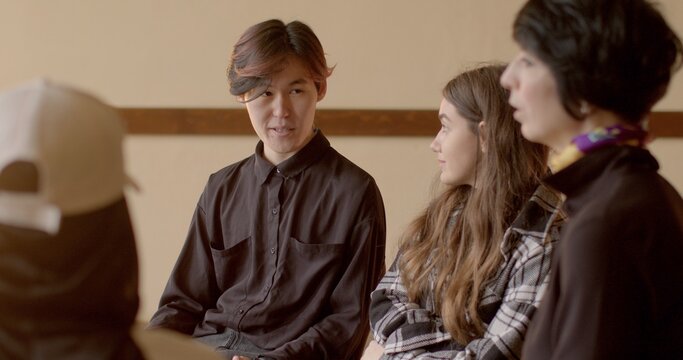 People sit in circle, talking. Pedagogical meeting with youth focuses on addressing challenges faced by troubled teens, including behavior modification and rehabilitation within troubled teen industry