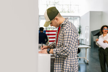 Voter placing ballot in ballot box polling place in America.