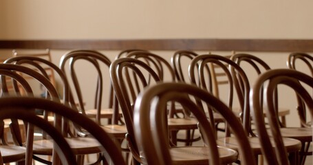 Empty chairs indoor evoke a sense of waiting and readiness for people to come together, whether for a concert, ceremony, or other occasions. Imminent commencement of an event, expectation of guests