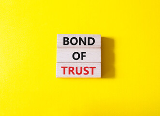 Bond of trust symbol. Wooden blocks with words Bond of trust. Beautiful yellow background. Business...
