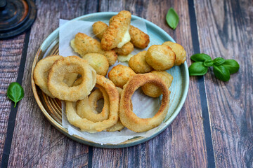 Selection of fast food snack. italian cheese breaded Mozzarella Sticks, Jalapeno Cheese nuggets, Onion Rings and mayo sauce.Italian street junk food
