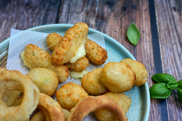 Selection of fast food snack. italian cheese breaded Mozzarella Sticks, Jalapeno Cheese nuggets, Onion Rings and mayo sauce.Italian street junk food