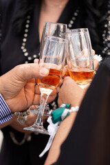 Hands with glasses filled with champagne connect them with the clink of a joyful party event at a social event.
Knocking glasses of champagne