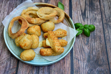 Selection of fast food snack. italian cheese breaded Mozzarella Sticks, Jalapeno Cheese nuggets, Onion Rings and mayo sauce.Italian street junk food