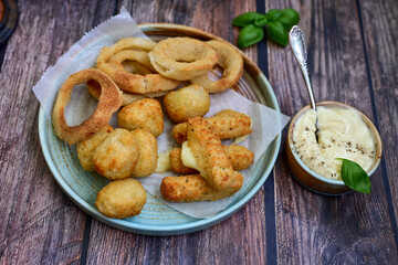 Selection of fast food snack. italian cheese breaded Mozzarella Sticks, Jalapeno Cheese nuggets, Onion Rings and mayo sauce.Italian street junk food