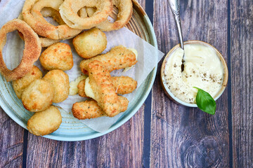Selection of fast food snack. italian cheese breaded Mozzarella Sticks, Jalapeno Cheese nuggets, Onion Rings and mayo sauce.Italian street junk food