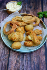 Selection of fast food snack. italian cheese breaded Mozzarella Sticks, Jalapeno Cheese nuggets, Onion Rings and mayo sauce.Italian street junk food