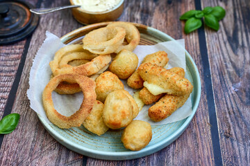Selection of fast food snack. italian cheese breaded Mozzarella Sticks, Jalapeno Cheese nuggets, Onion Rings and mayo sauce.Italian street junk food
