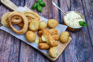 Selection of fast food snack. italian cheese breaded Mozzarella Sticks, Jalapeno Cheese nuggets, Onion Rings and mayo sauce.Italian street junk food